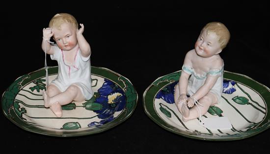 Two bisque baby dolls and two Doulton plates (4)